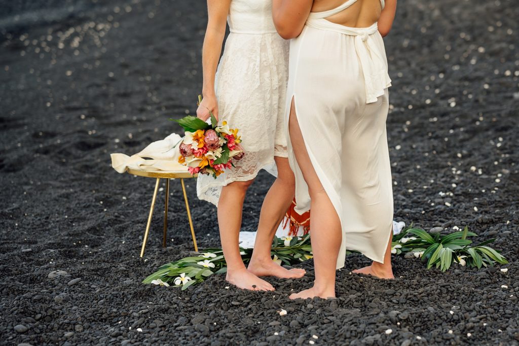 white wedding dress against the black sand beach during an elopement