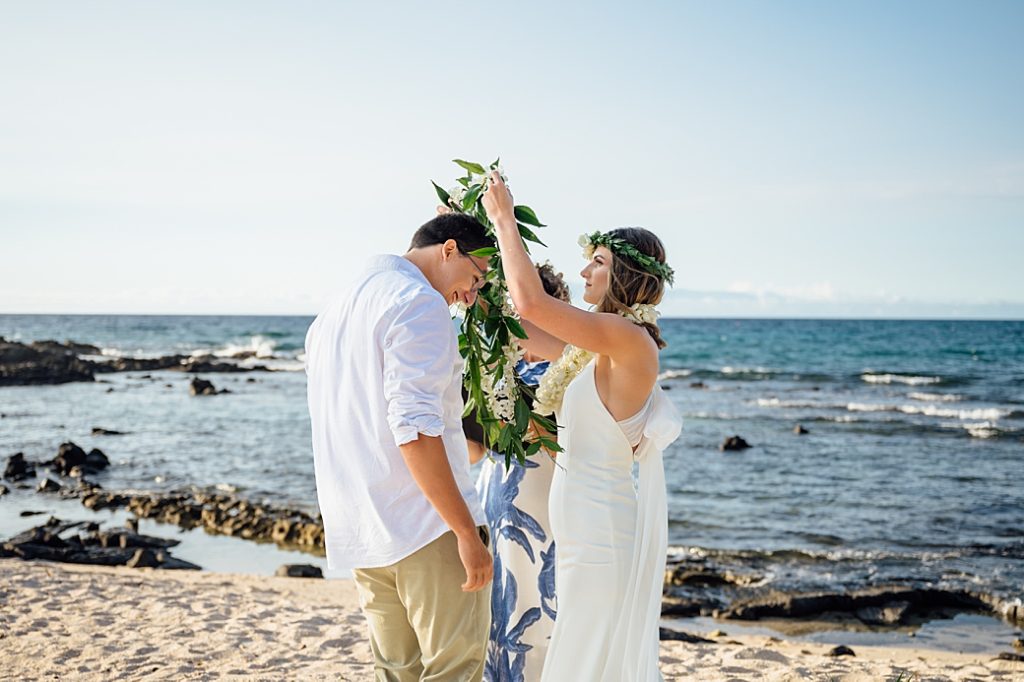Bride putting lei over groom during their elopement in Hawaii