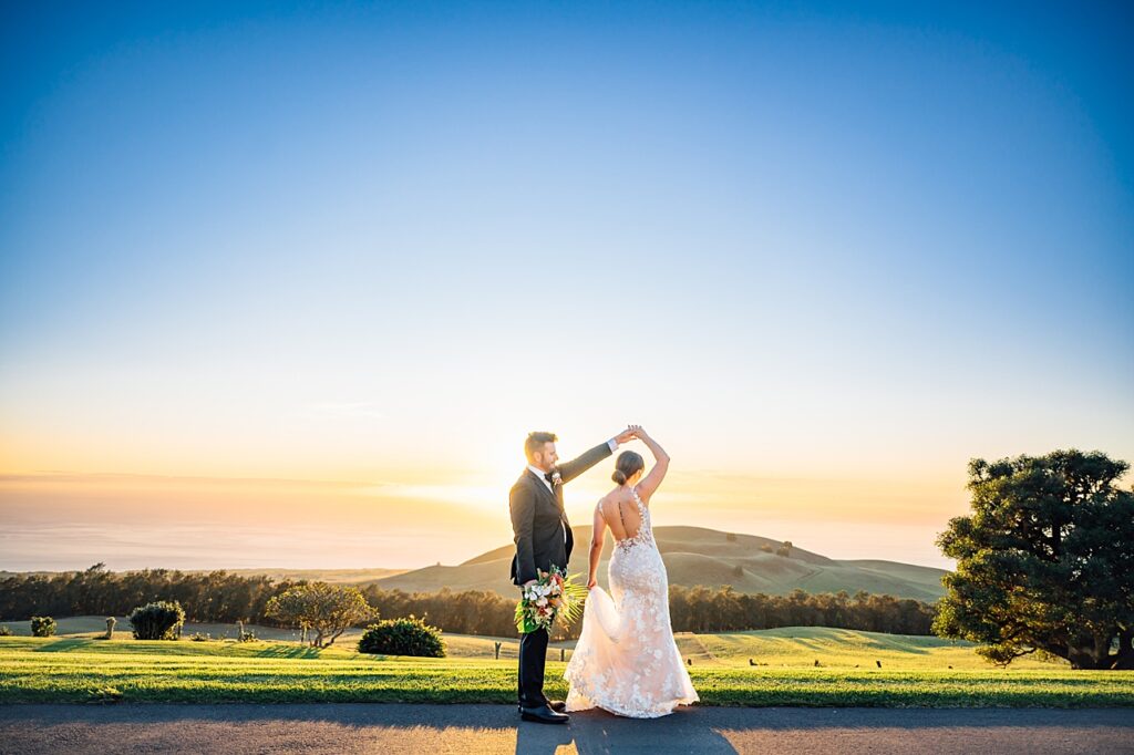 couple dancing agaisnt the sunset at their hawaii wedding