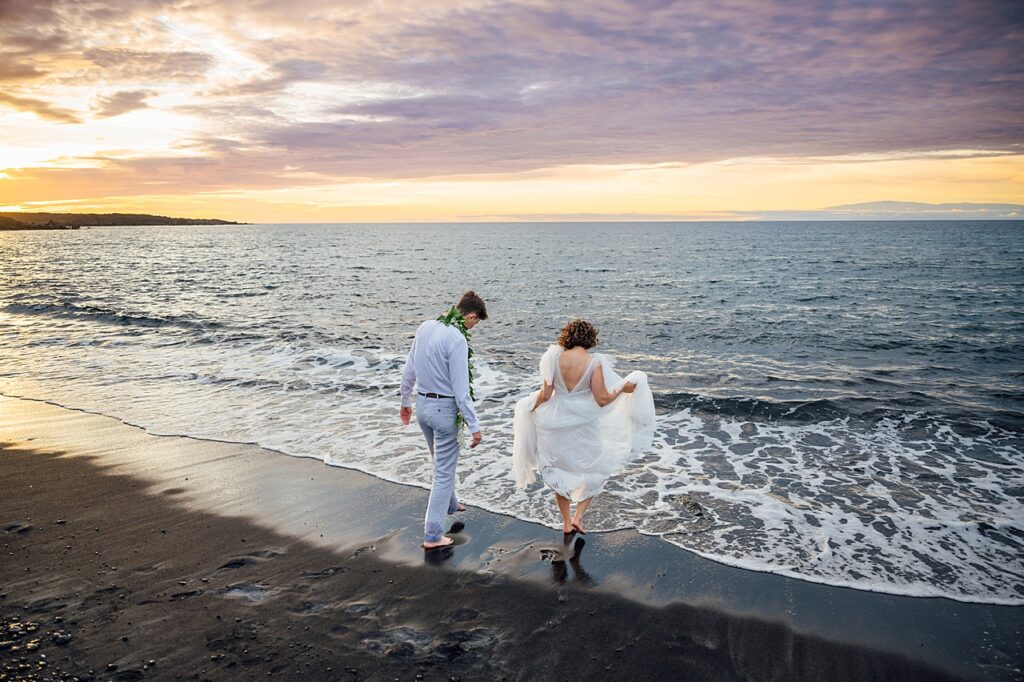 newlyweds on a black sand beach at sunset